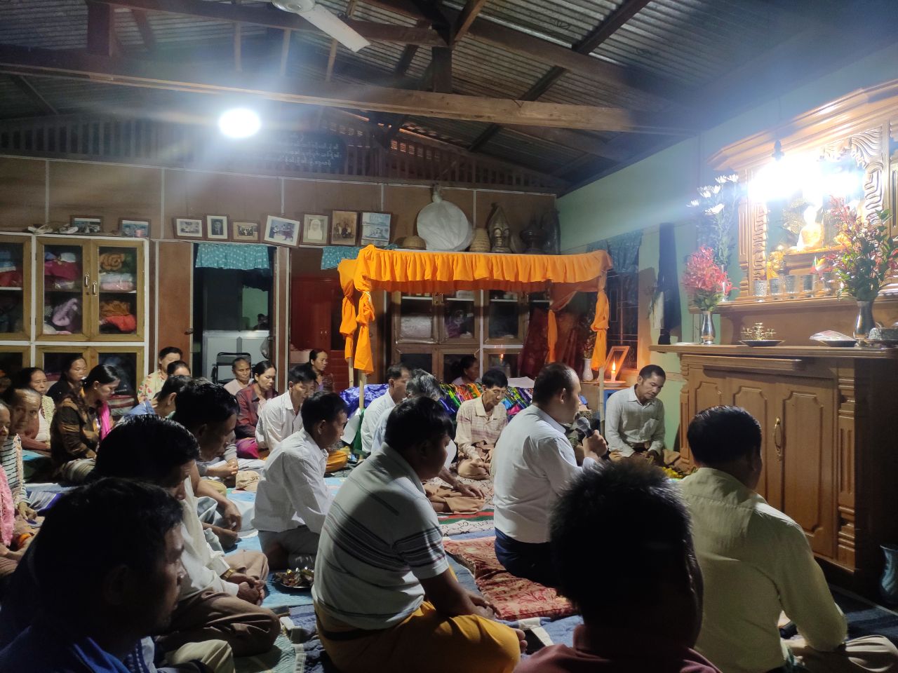 Zare Sai Jom Hlaing Han reciting lik long poetry in a Shan funeral, with the family members of the deceased and elderly villagers listening to the recitation and paying homage to the altar of the Buddha in Namkham, Northern Shan State, Myanmar. Photo: Bikash K. Bhattacharya