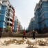 Construction workers pass a farmer and his goats in front of newly constructed residential buildings in Gushi, Henan province. Photograph: David Gray/Reuters