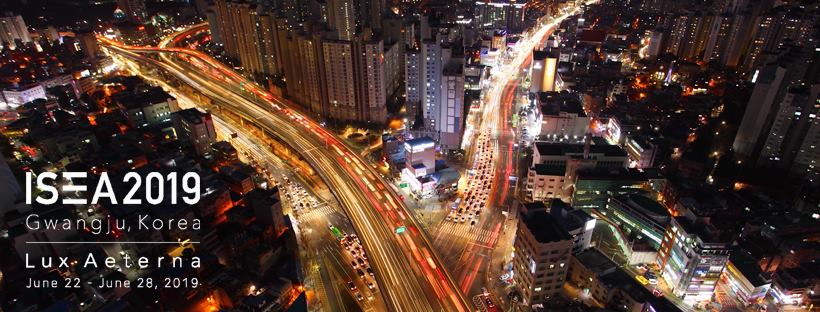 Overhead image of city at night with lights and traffic. Poster for ISEA 2019 conference in Gwangju on electronic art.