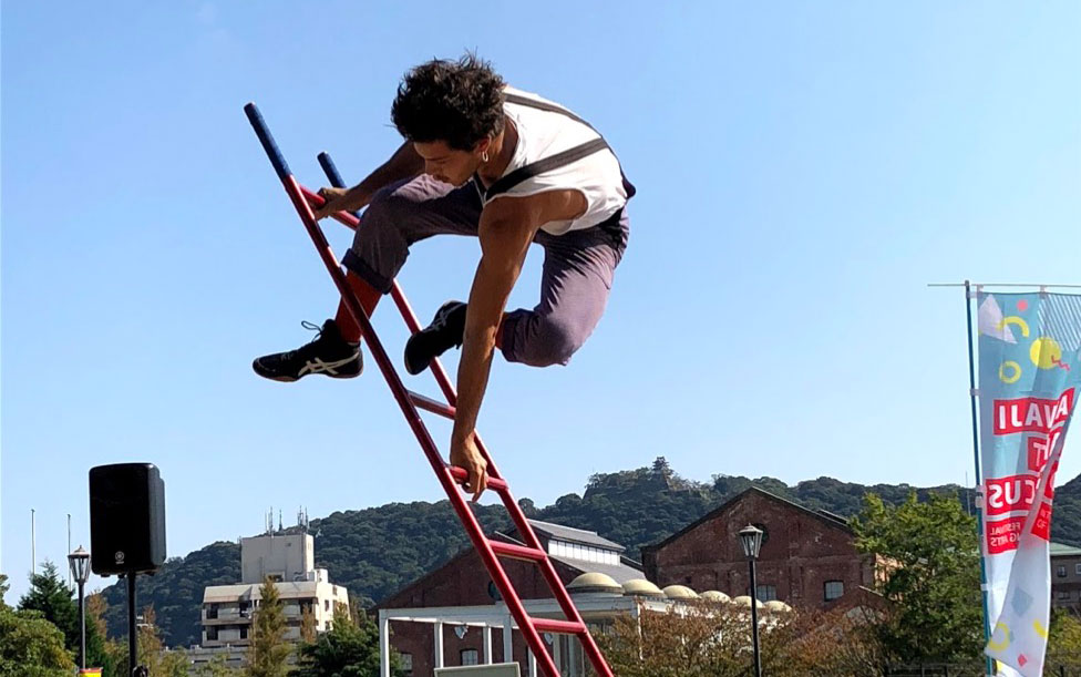 Nicolas Provot, contemporary circus artist doing a balancing act on ladder