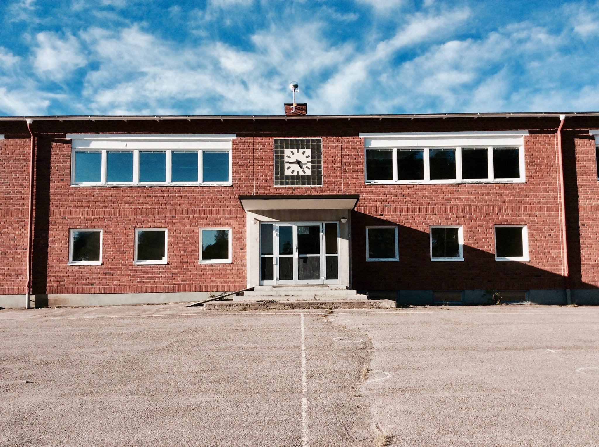 Northern Sustainable Futures building, red brick with evenly spaced windows, and a blue sky with clouds can be seen behind.