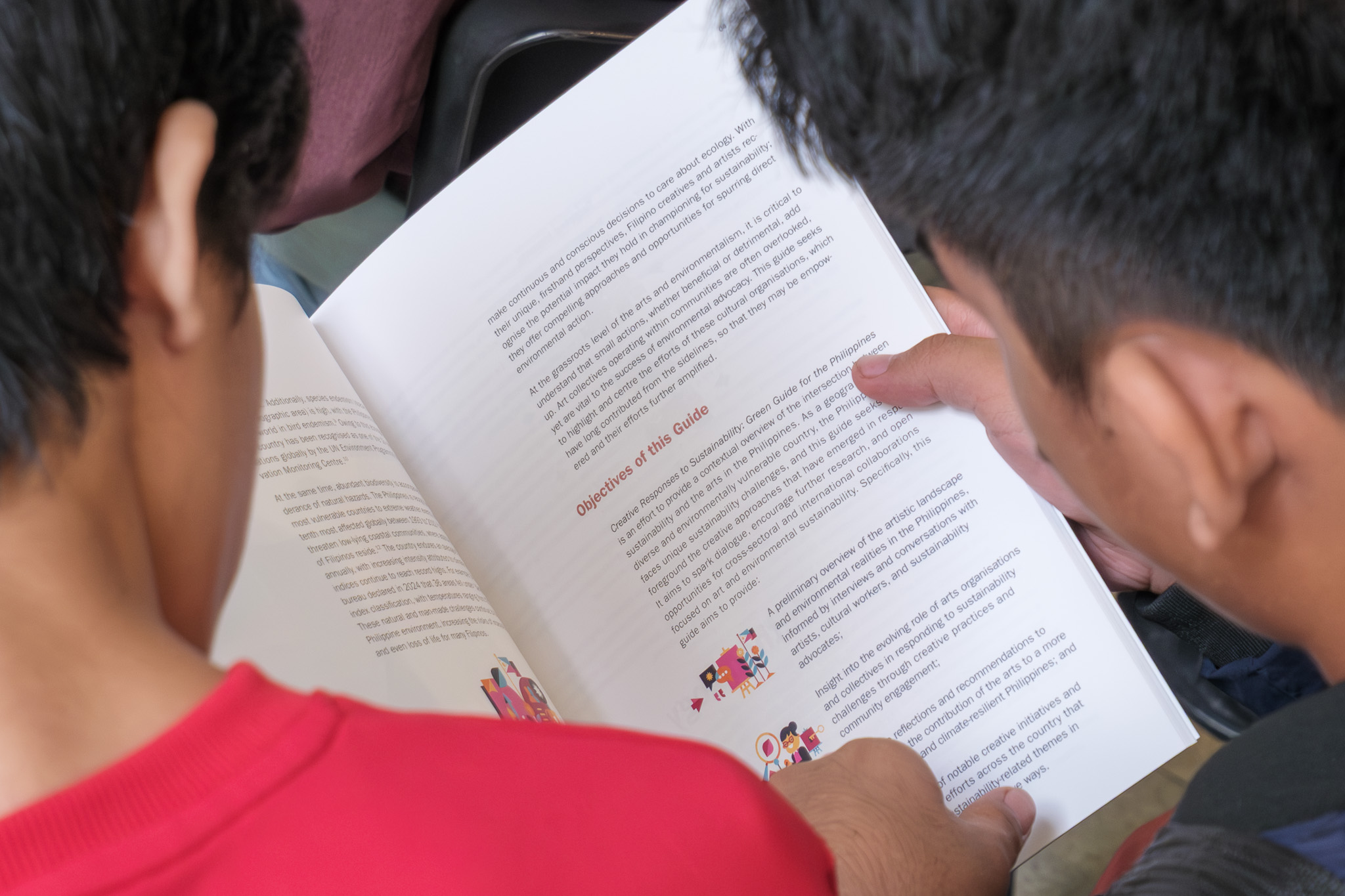 Attendees leaf through the Green Guide for the Philippines, engaging with its call for culturally grounded and ethically conscious creative practice.