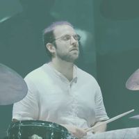 A person drumming on stage.