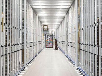 A storage corridor with some paintings being pulled out.