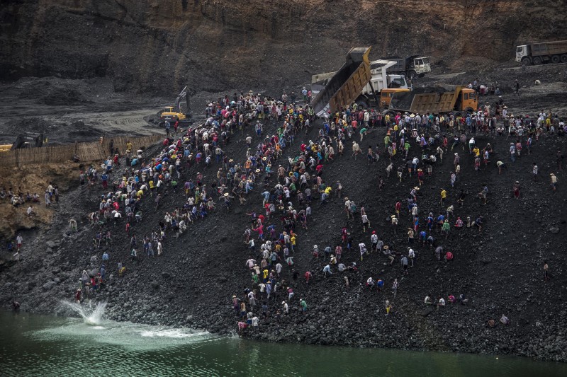 Small-scale miners search for stone as dump trucks from a government-licensed jade mining company dump waste in Hpakant, Kachin State, Myanmar, April 25, 2015. Jade mining a perilous job for small-scale miners especially when banks and slag heaps are de-stabilized by monsoon rain. A massive landslide in November 2015 at a government-licensed company waste-dumping site reportedly killed 114 people.